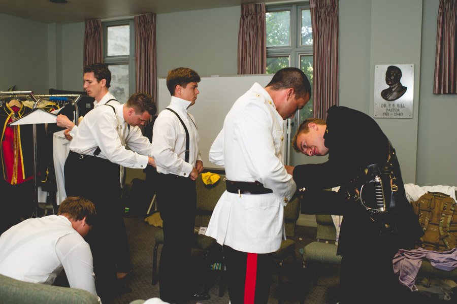 Groomsmen prepare uniforms and suits while getting ready at San Antonio church