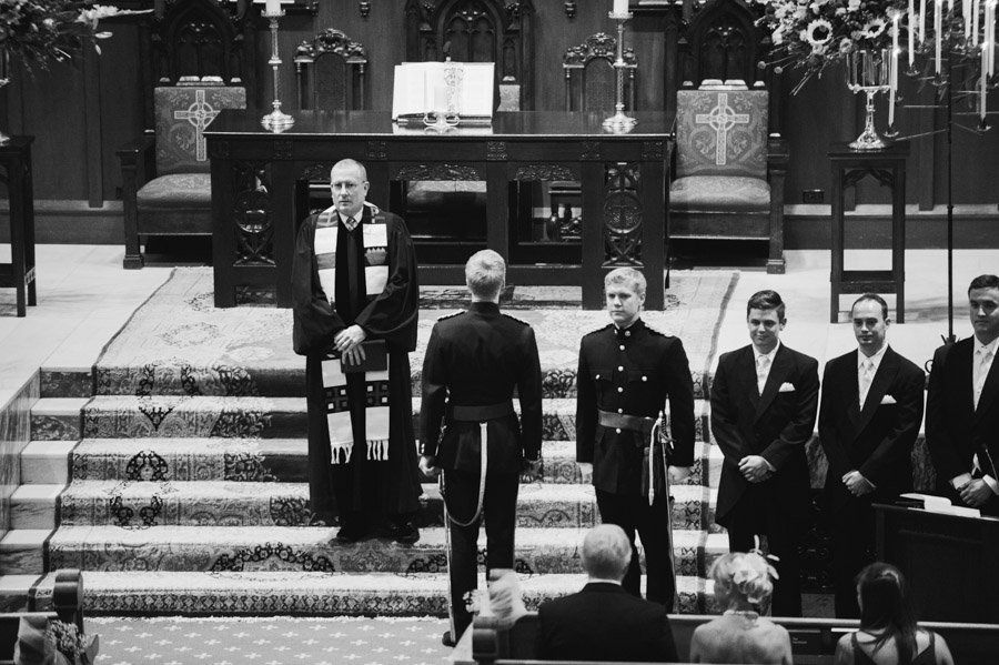 the Groom does a traditional British first look by not facing the back of the church until he receives the signal during his wedding in San Antonio