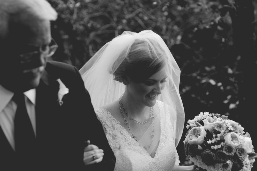 bride and her dad walk down the aisle at laguna gloria in austin