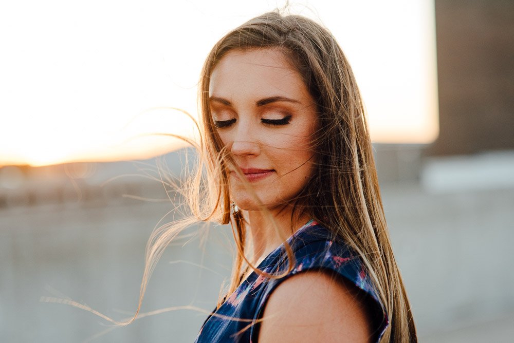 girl hair flying in the wind on top of a parking garage