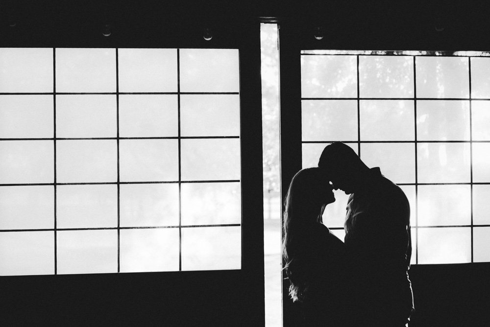 silhouette of couple beside glass barn doors at their fort worth engagement session, modern engagement session photography, modern wedding photography in fort worth texas