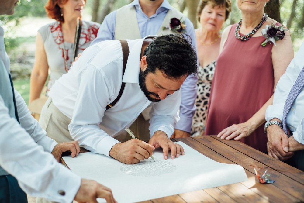 signing the ketubah at an outdoor wedding at the wildflower barn in dripping springs