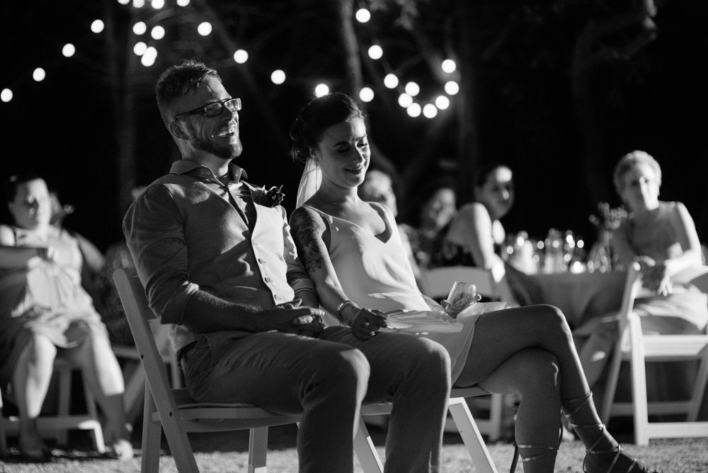 black and white photo of a bride and groom laughing during toasts at a summer austin wedding