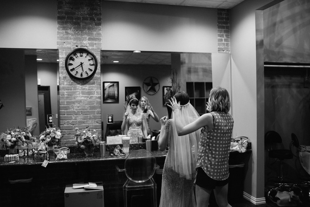 bride putting her veil on at the cotton mill in mckinney
