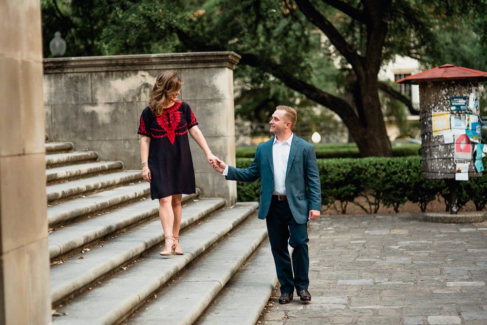 a couple walks hand in hand along a staircase during their UT campus engagement photographs