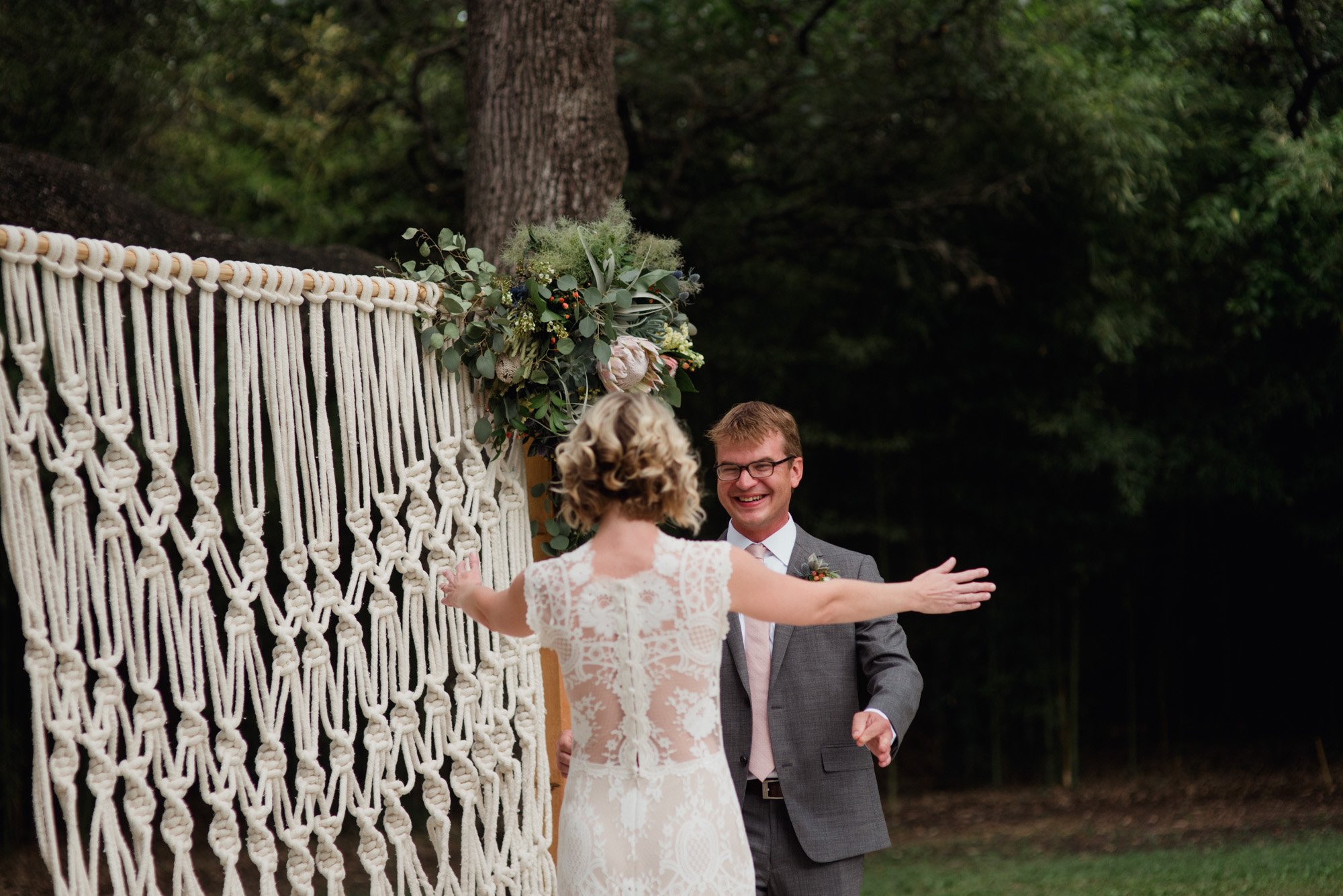 first look in front of a macrame backdrop at a summer wedding in austin texas