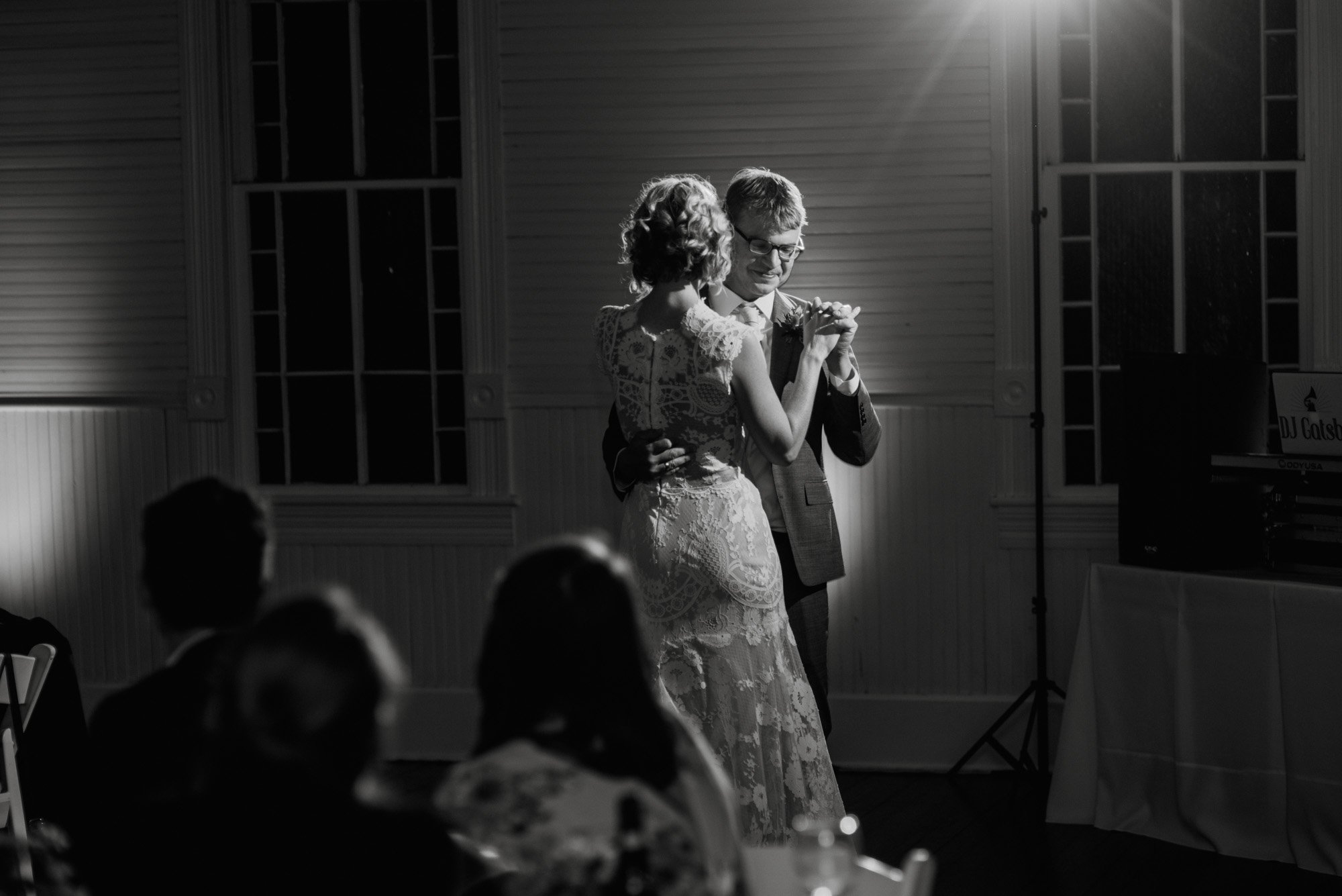 first dance together under the spotlight at a small wedding venue in south austin, bright, happy wedding photography, classic black and white wedding dance photographs, first dance portraits, colorful wedding photographers