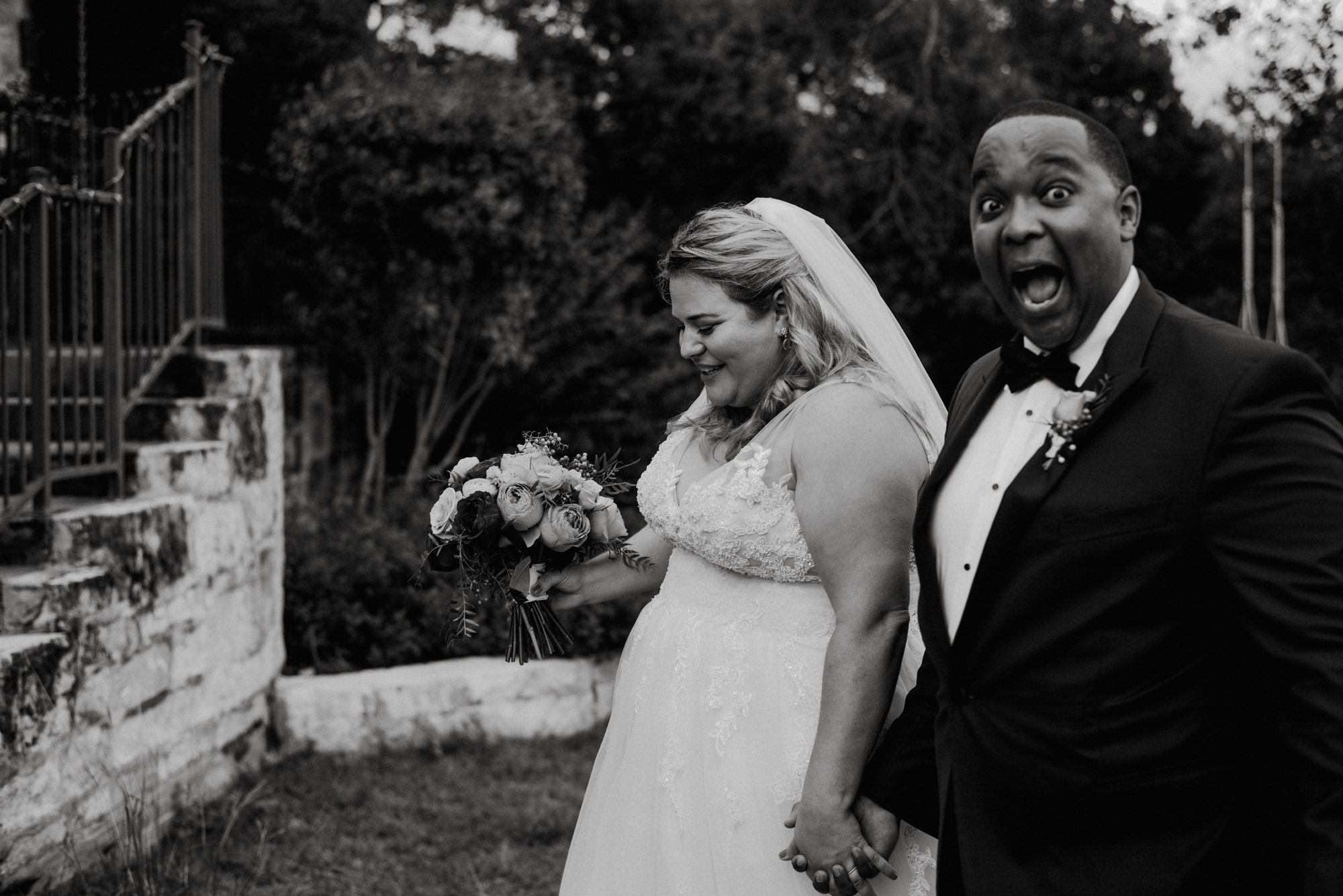 candid photo of groom making face after walking down the aisle, black and white wedding phojournalism