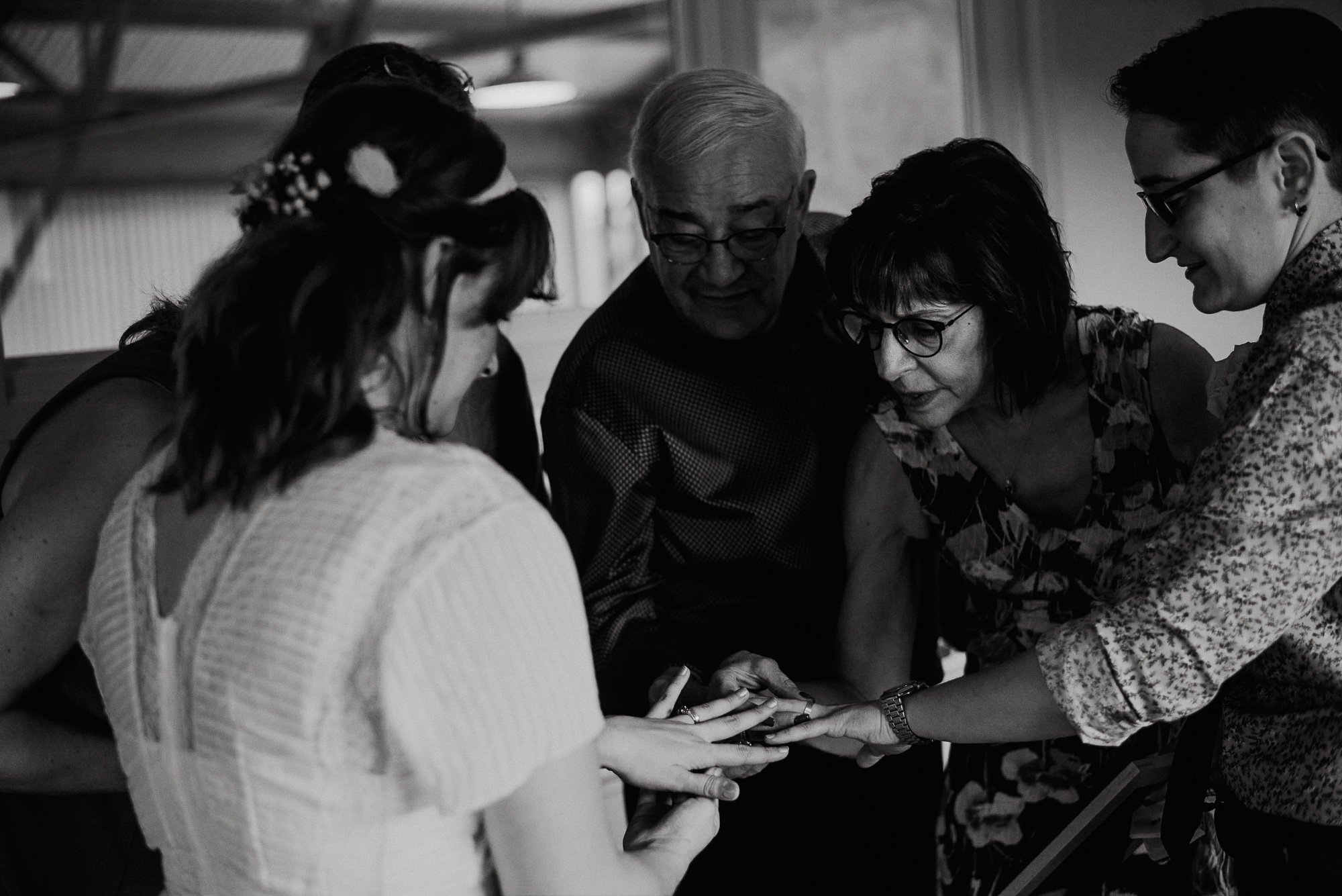 photojournalistic wedding photographers in austin texas, modern wedding photography, black and white emotional wedding moments, parents of the couple examine the wedding bands chosen by a same sex couple at a fall wedding in austin texas