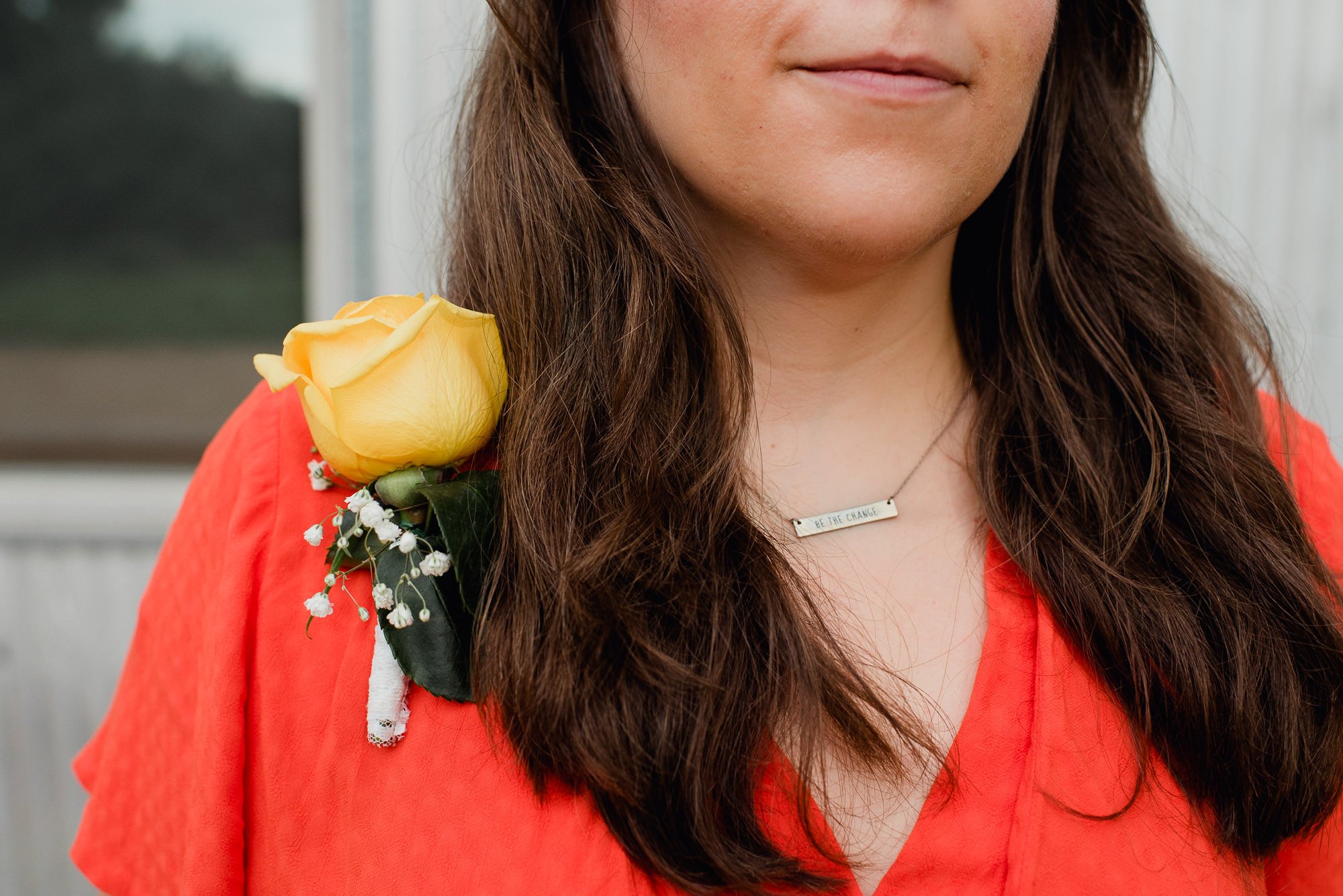 be the change necklace on a woman wearing an orange dress outside