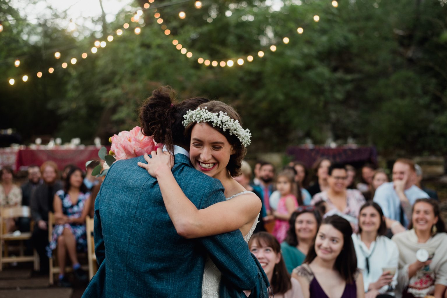 bride and groom embrace with smiles at their backyard Austin wedding in the fall