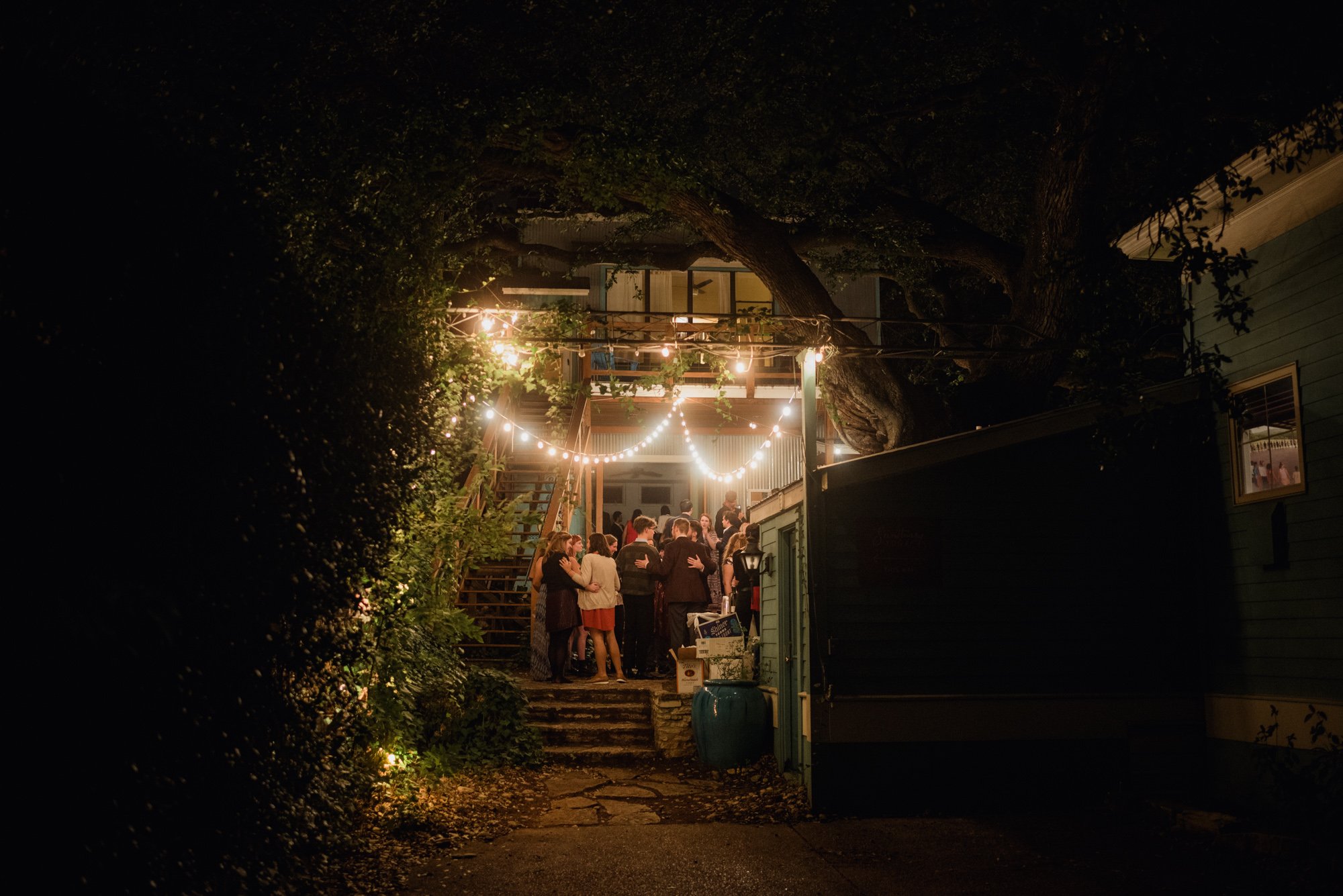 environmental photo of wedding guests underneath the string lights