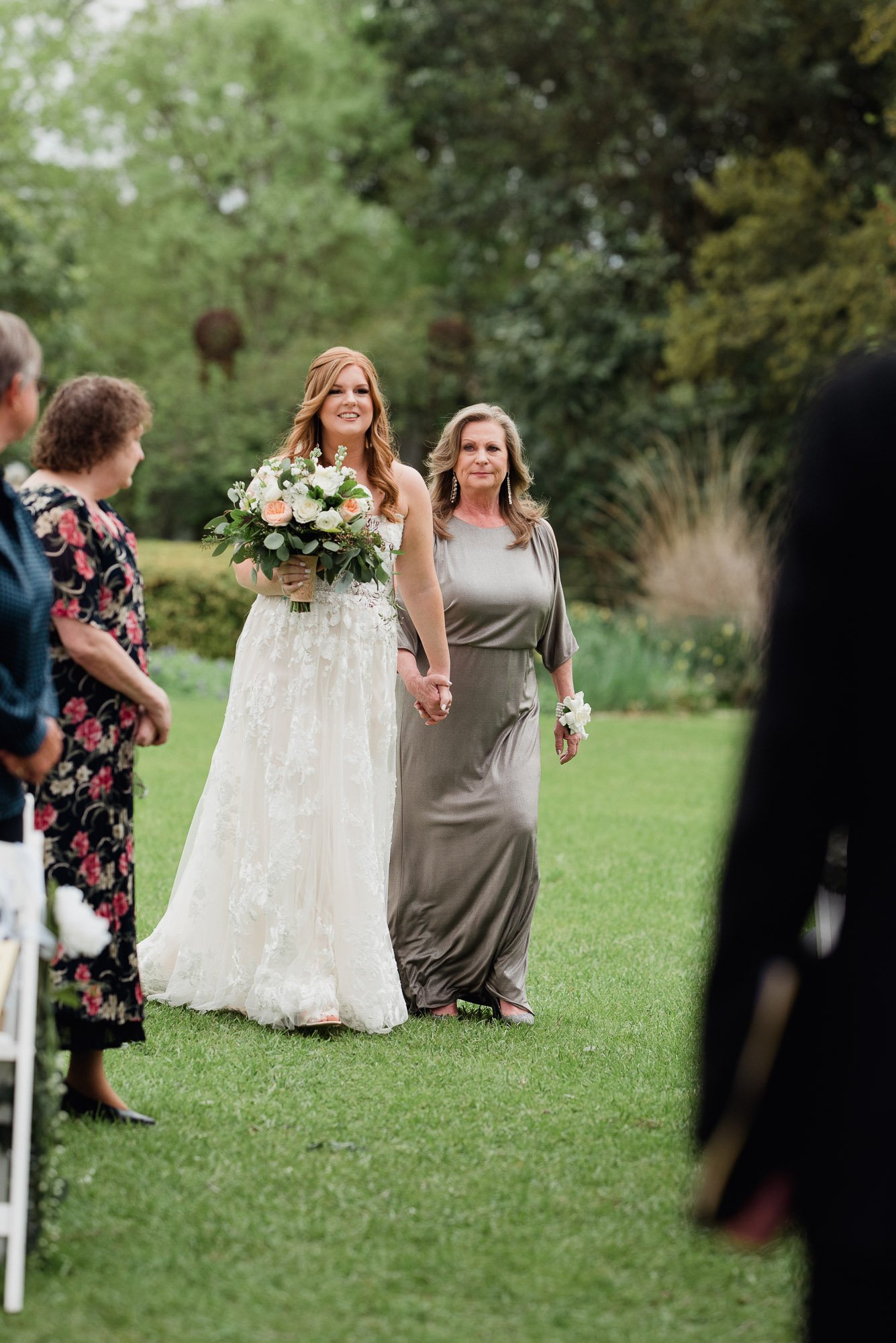 bride walking down aisle with her mom at the barr mansion