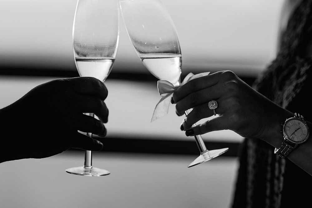 newly engaged couple toasts with champagne in black and white