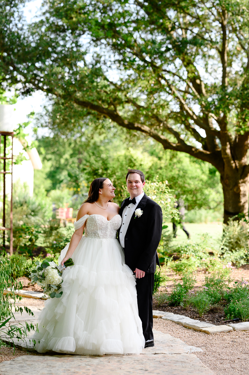 bride and groom formal pictures with greenery in the bakground