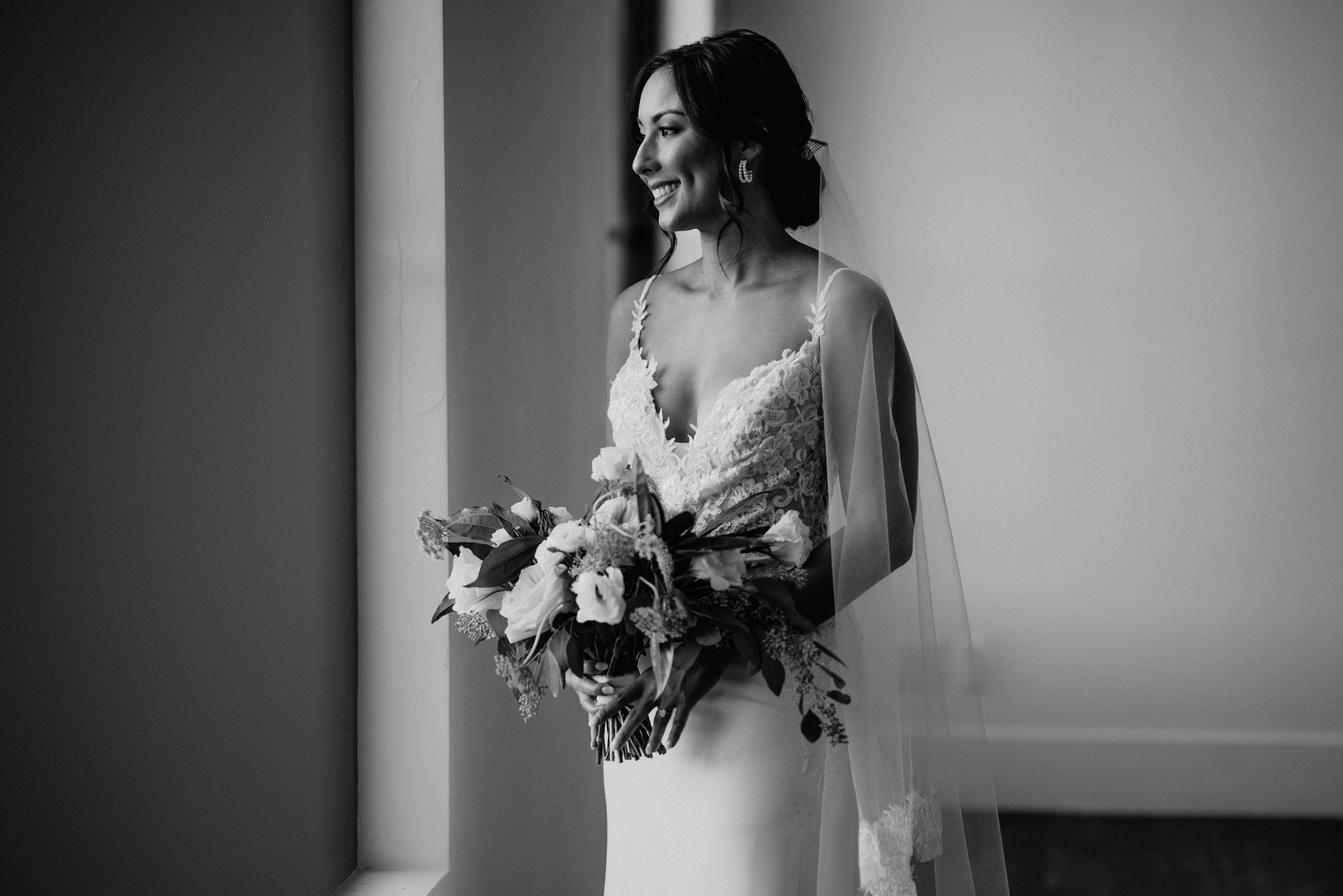 dramatic black and white portrait or a bride looking out the window, black and white bridal session photographs, bridal portrait poses, romantic bridal portrait photographs