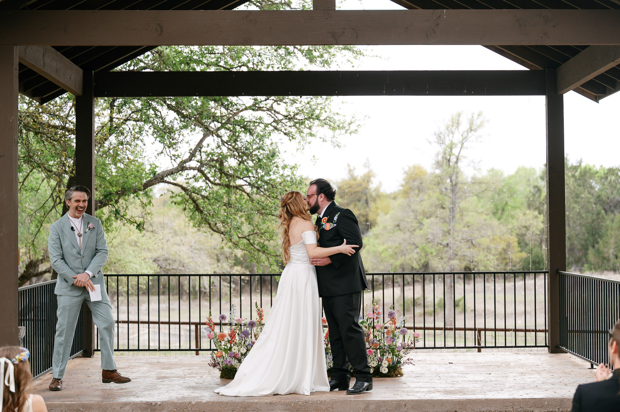 Bride and groom share their first kiss at their spring wedding at Ranch Austin wedding venue
