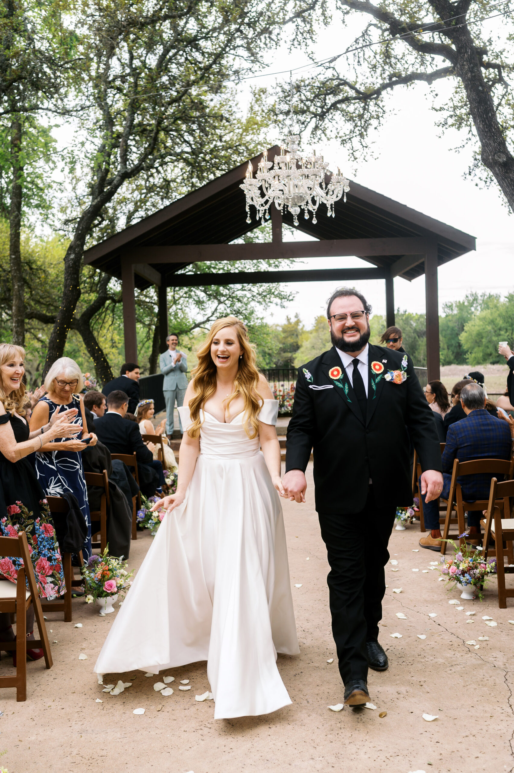 Bride and groom hand in hand, walk back down the aisle at their wedding at Ranch Austin