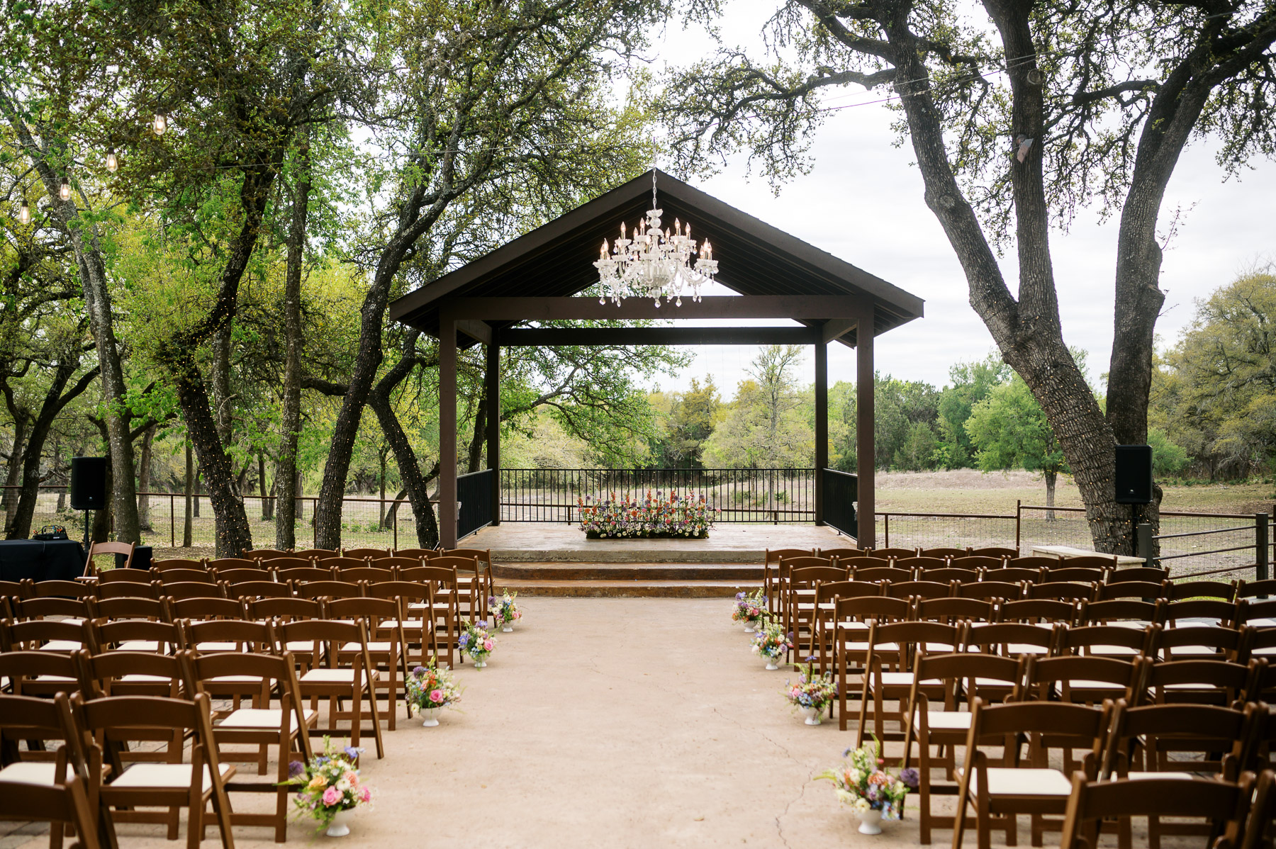 Spring wedding cermony set up with a floral meadow focal point at Ranch Austin Wedding Venue