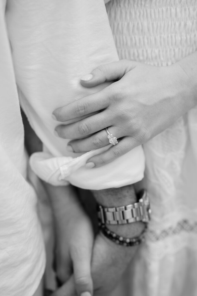 detail of a newly engaged couple's left hand